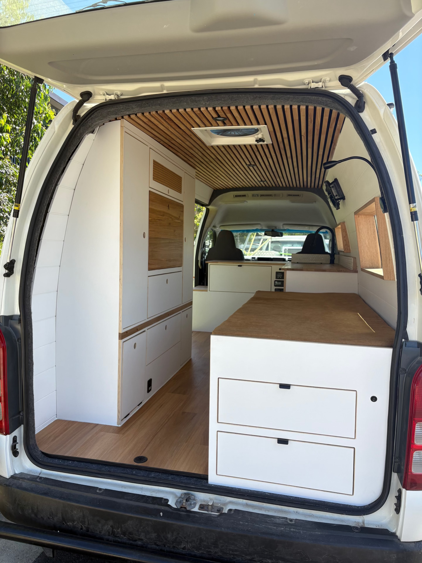 Open rear doors showing bed, drawers and cabinetry